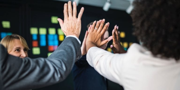 Business people give high fives